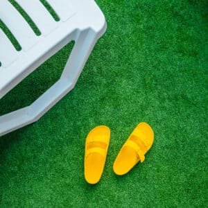 a chair and a pair of slippers on the artificial grass