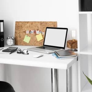 an office desk with laptop and notebooks